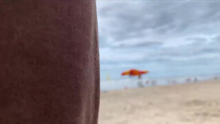 Milf holds my penis tightly in her hand until I cum right on the beach