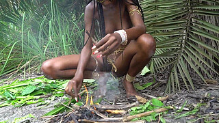 Hot African native woman cooking in the jungle