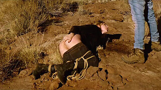 Big-butt blonde gets her anus whipped, then gets rough anal sex in dirt and piss -- a real BDSM session outdoors in the Western USA with Rebel Rhyder