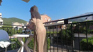 Nude in public on a balcony overlooking the road.