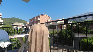 Nude in public on a balcony overlooking the road.