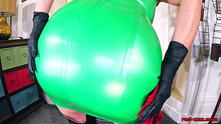 Red XXX masturbates in a green latex dress