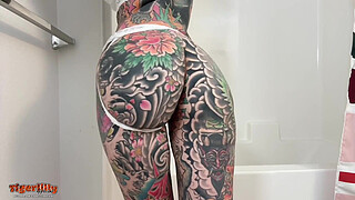 Tattooed MILF with big hooters & split tongue masturbating in shower until she squirts