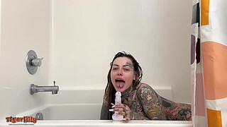 Tattooed MILF with big hooters & split tongue masturbating in shower until she squirts
